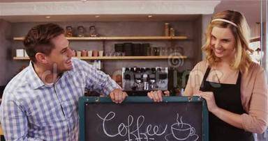 咖啡馆女服务员和男子站在咖啡招牌前